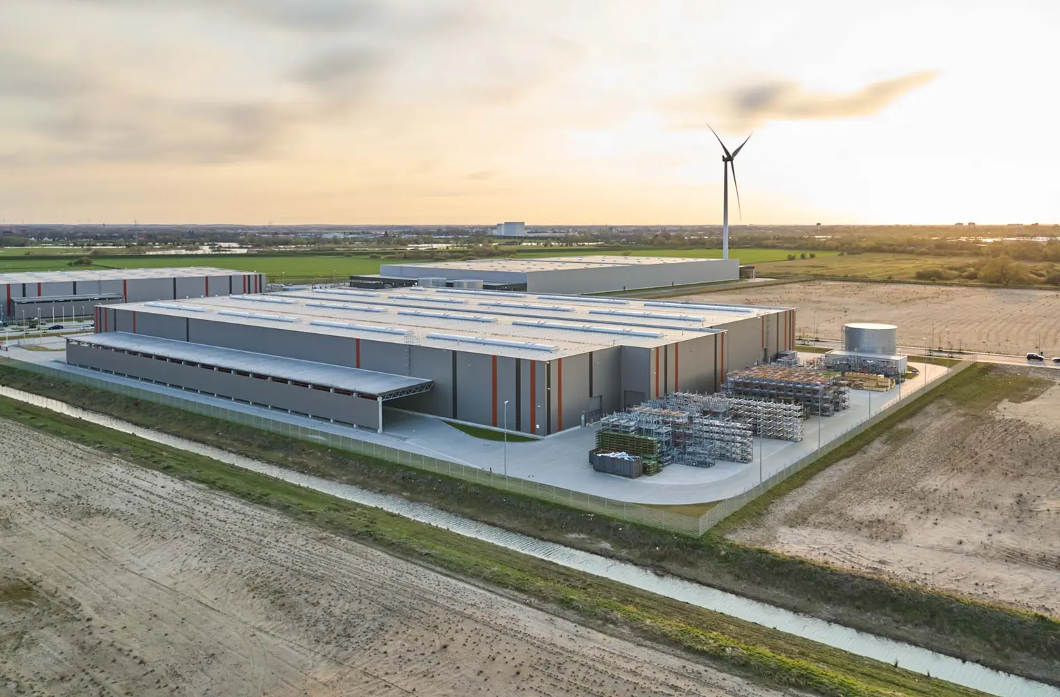 Luftaufnahme der Lagerhalle Hansalinie Bremen - Linde + Wiemann. Dargestellt sind zwei große Lagerhallen mit verschiedenen Materialien, die davor gestapelt sind.