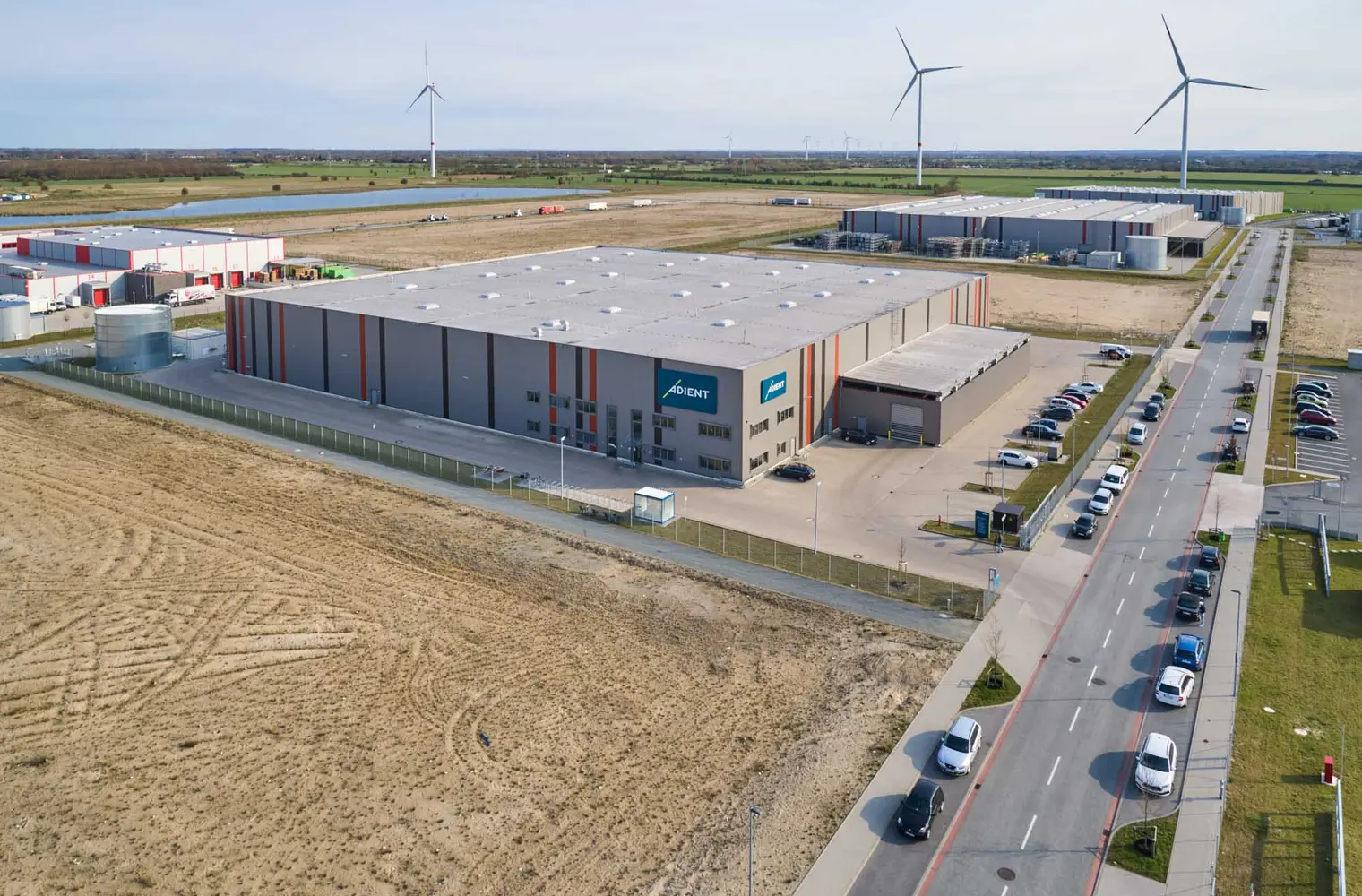 Luftaufnahme der Lagerhalle Hansalinie Bremen - Adient. Dargestellt ist ein großes Gebäude mit Anbau für Zulieferungen.