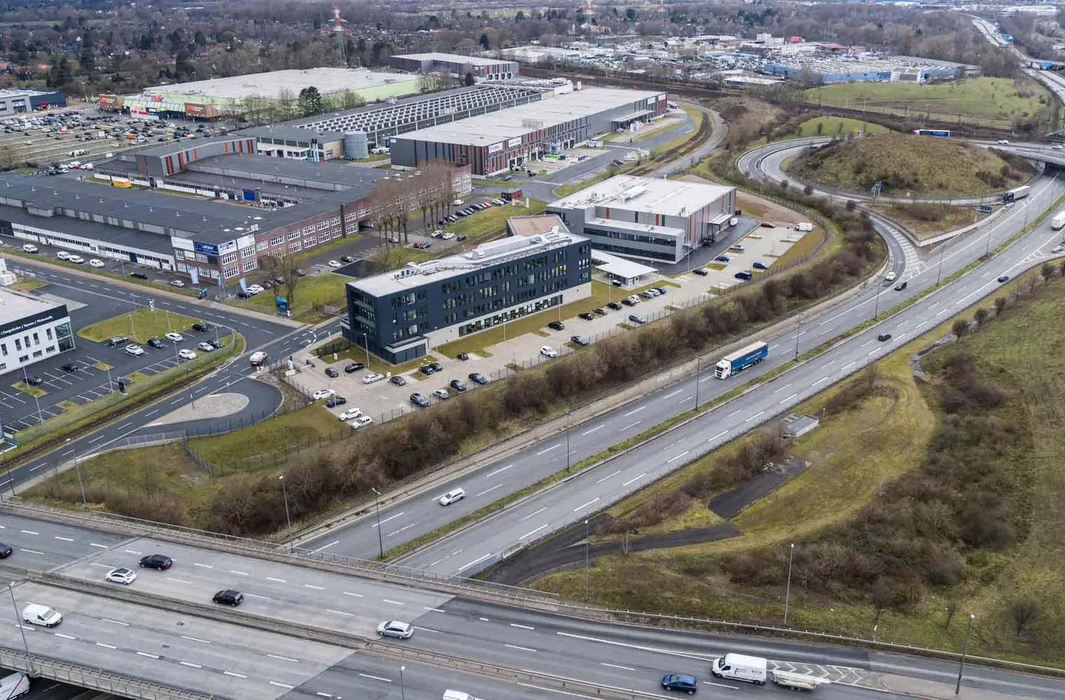 Luftaufnahme des Geländes "Lloyd Industriepark Bremen". Abgebildet werden verschiedene Gebäude und Lagerhallen. Das Gelände ist weitläufig, begrünt und mit verschiedenen Parkplätzen ausgestattet.