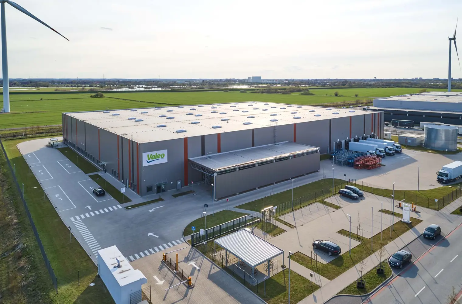 Luftaufnahme der Lagerhalle Hansalinie Bremen - Valo. Dargestellt ist eine große Lagerhalle mit überdachtem Vorbau für die Lagerung sowie ein gesicherter Parkplatz.